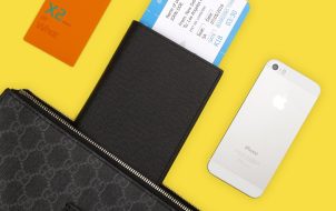 汇率计算场景案例配图，行李箱旁散放护照与外币现金和一张手写预算清单，机场落地窗逆光