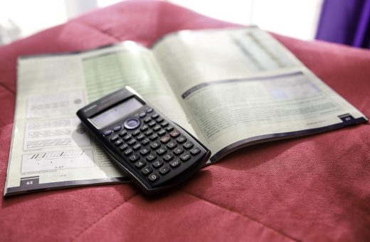 金融数据分析师在双屏工作站前对比多个汇率计算工具的实时报价，屏幕显示K线走势图与数字对比表格，专业冷色调氛围